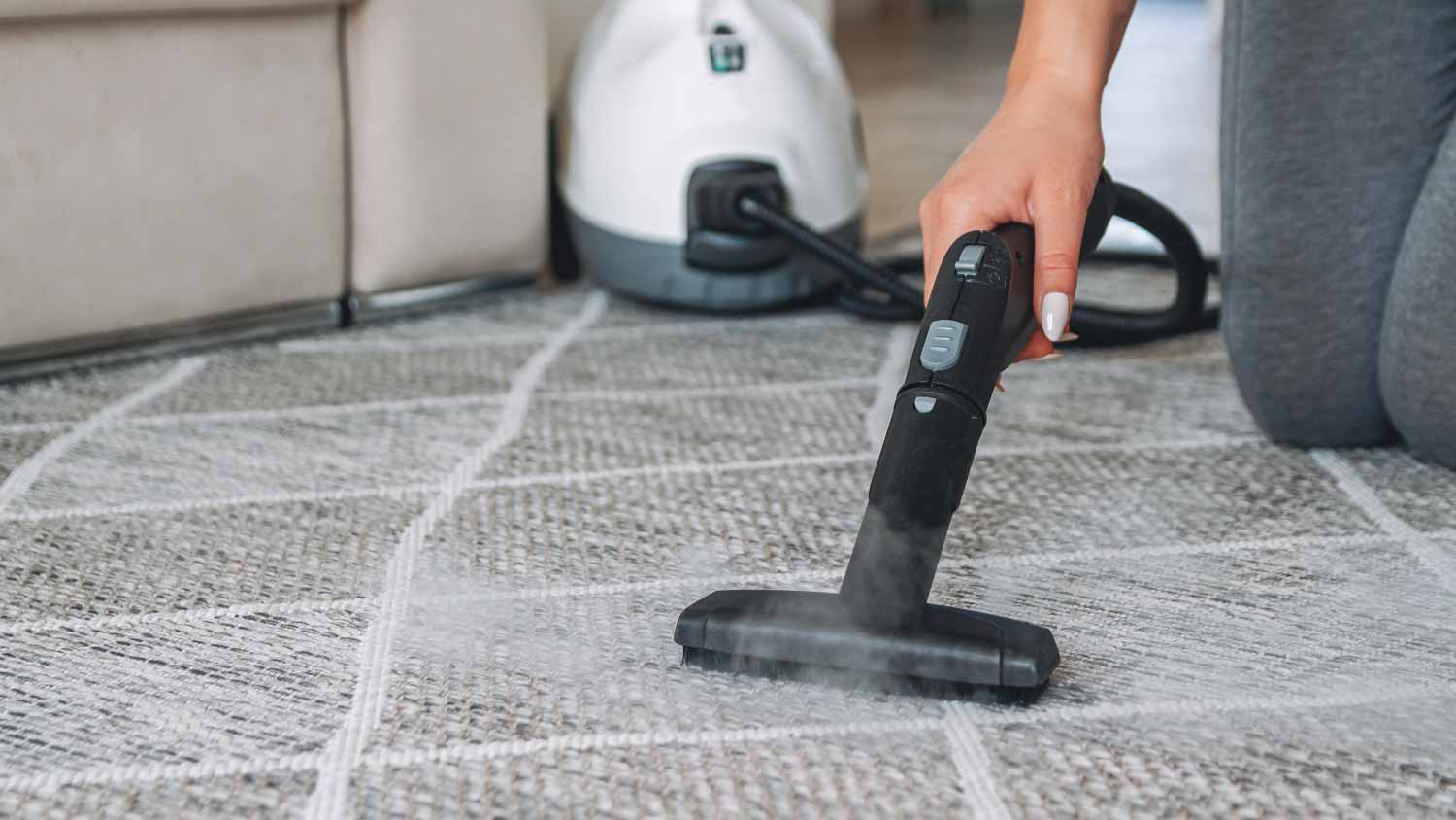 Woman cleaning carpet with a steam cleaner