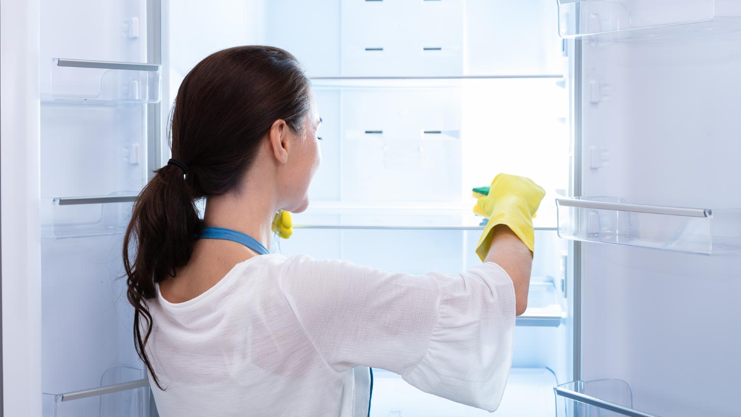 Woman cleaning refrigerator