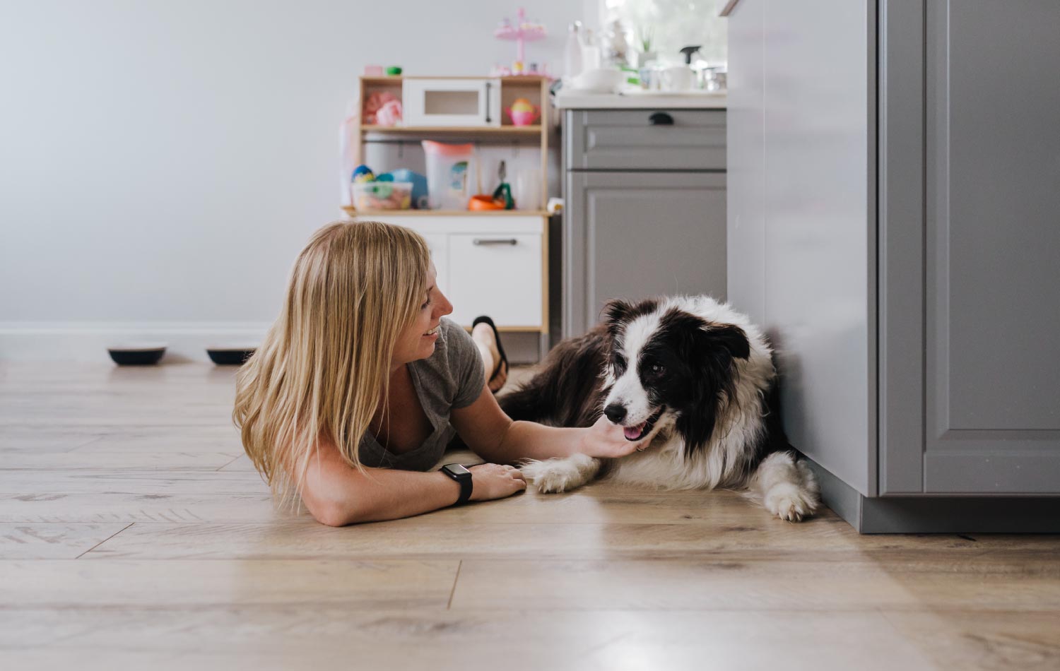 A woman with her dog laying on the floor