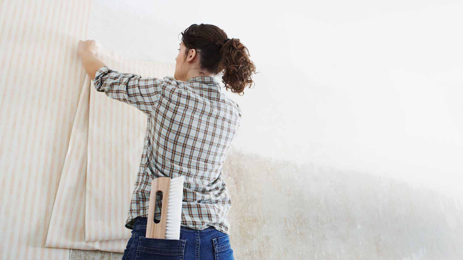 Woman hanging wallpaper
