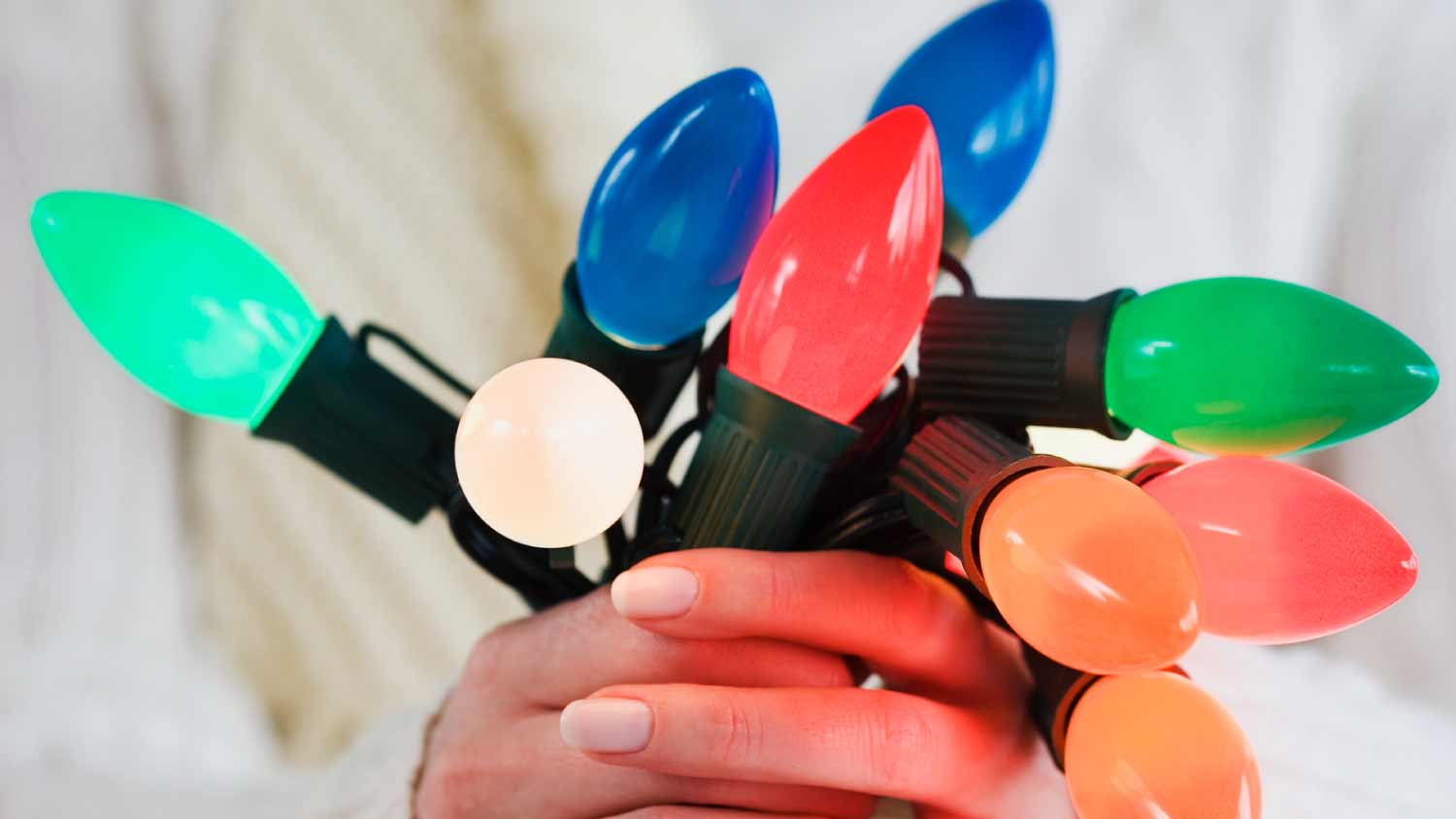 Woman holding bunch of Christmas lights