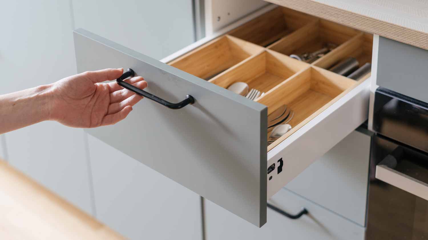 Woman opening cutlery drawer