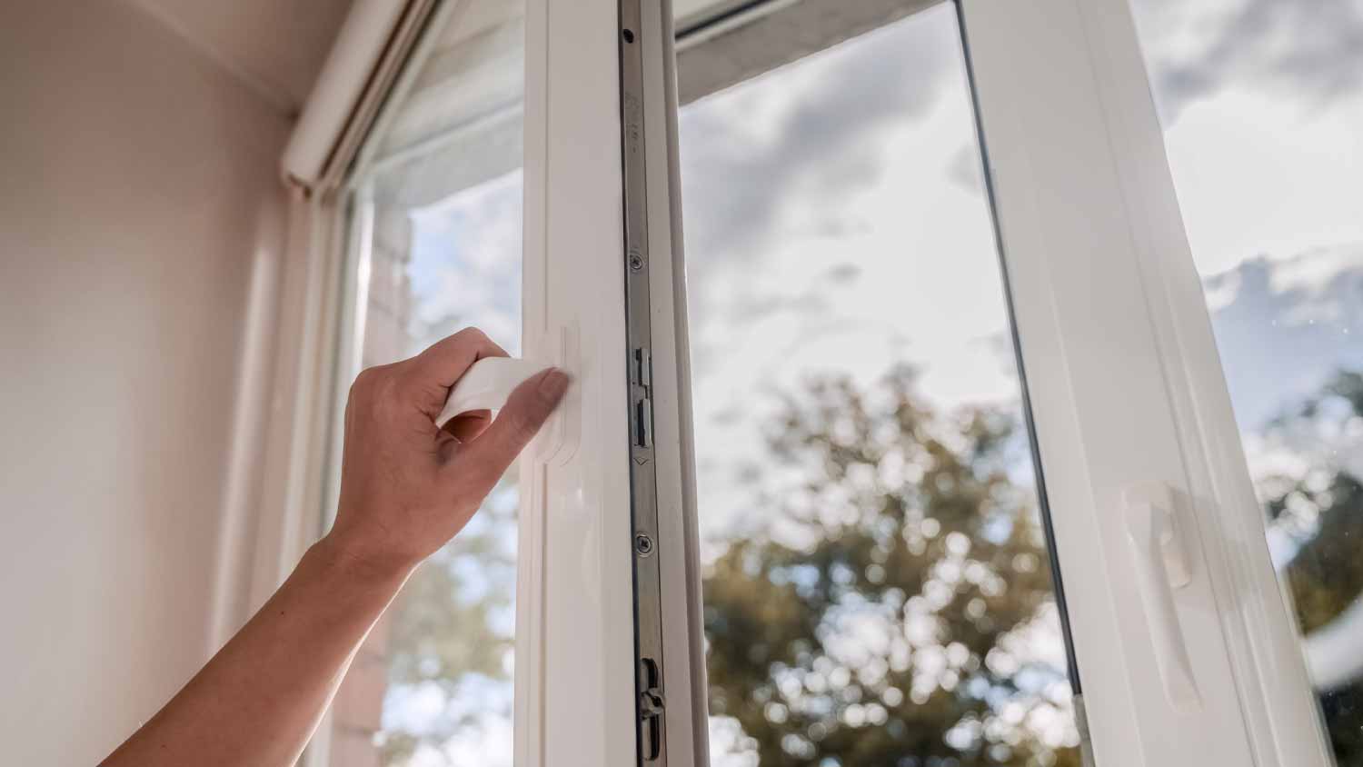Woman opening vinyl plastic window