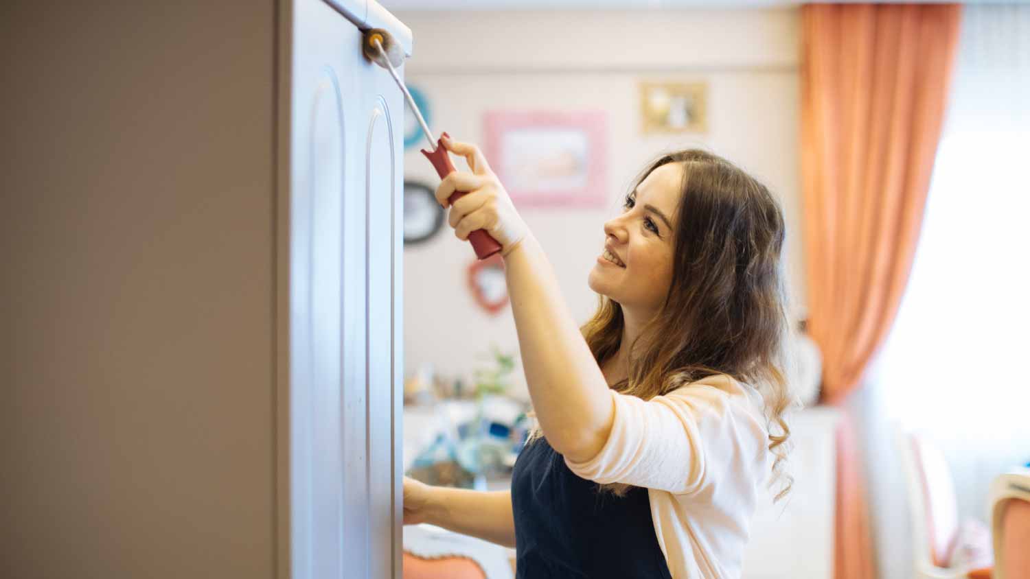 Woman painting a cabinet 