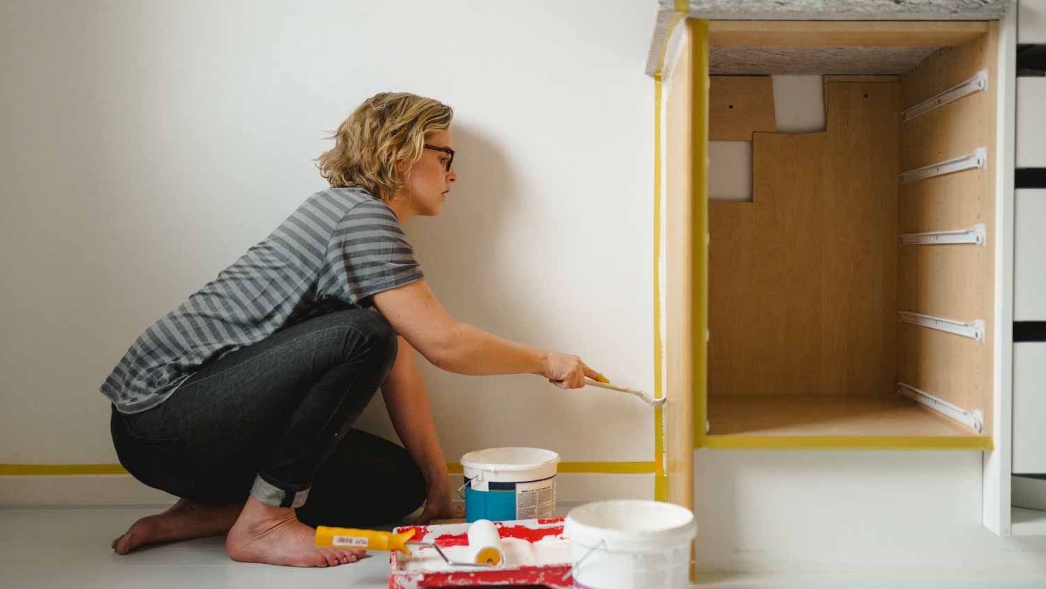 Woman painting cupboard