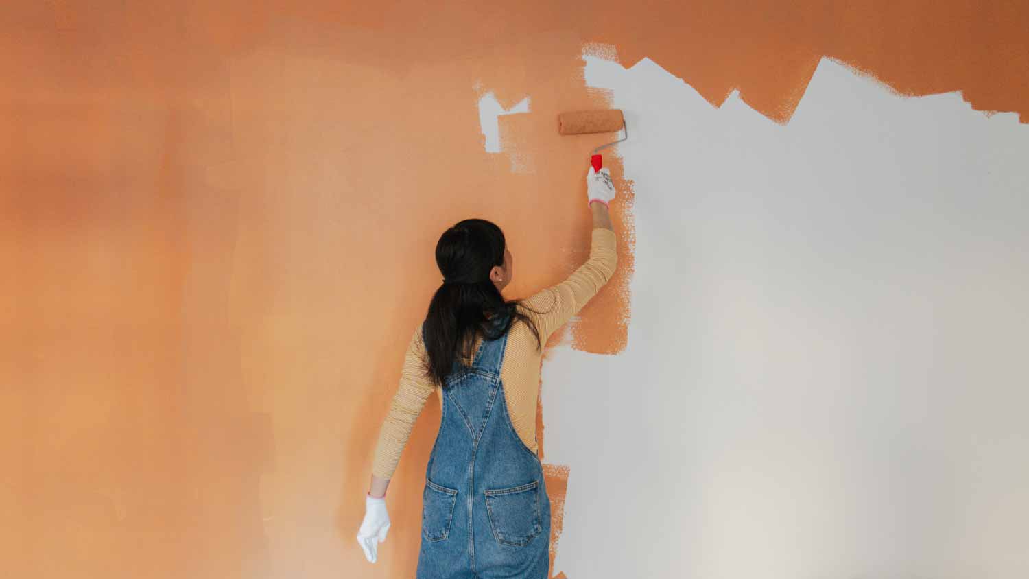 Woman painting walls of her living room