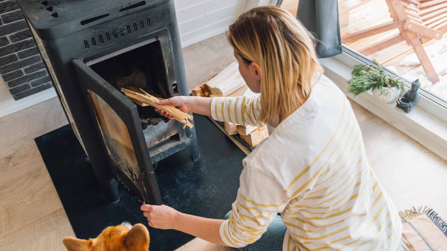 Woman putting wood in stove