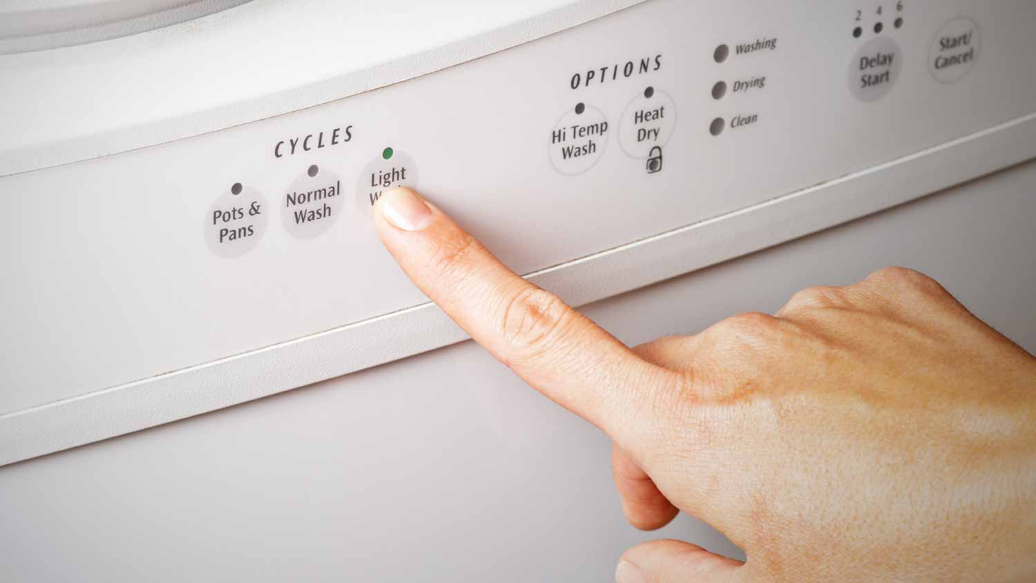 Woman setting the dishwasher cycle