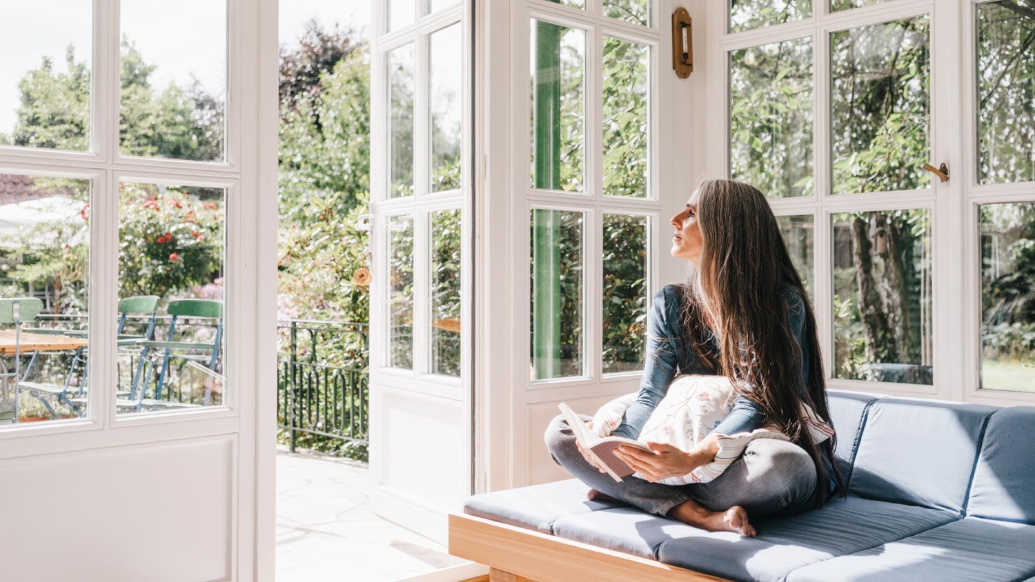 A woman sitting with book on lounge