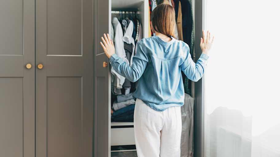 Woman standing in front of hanger rack
