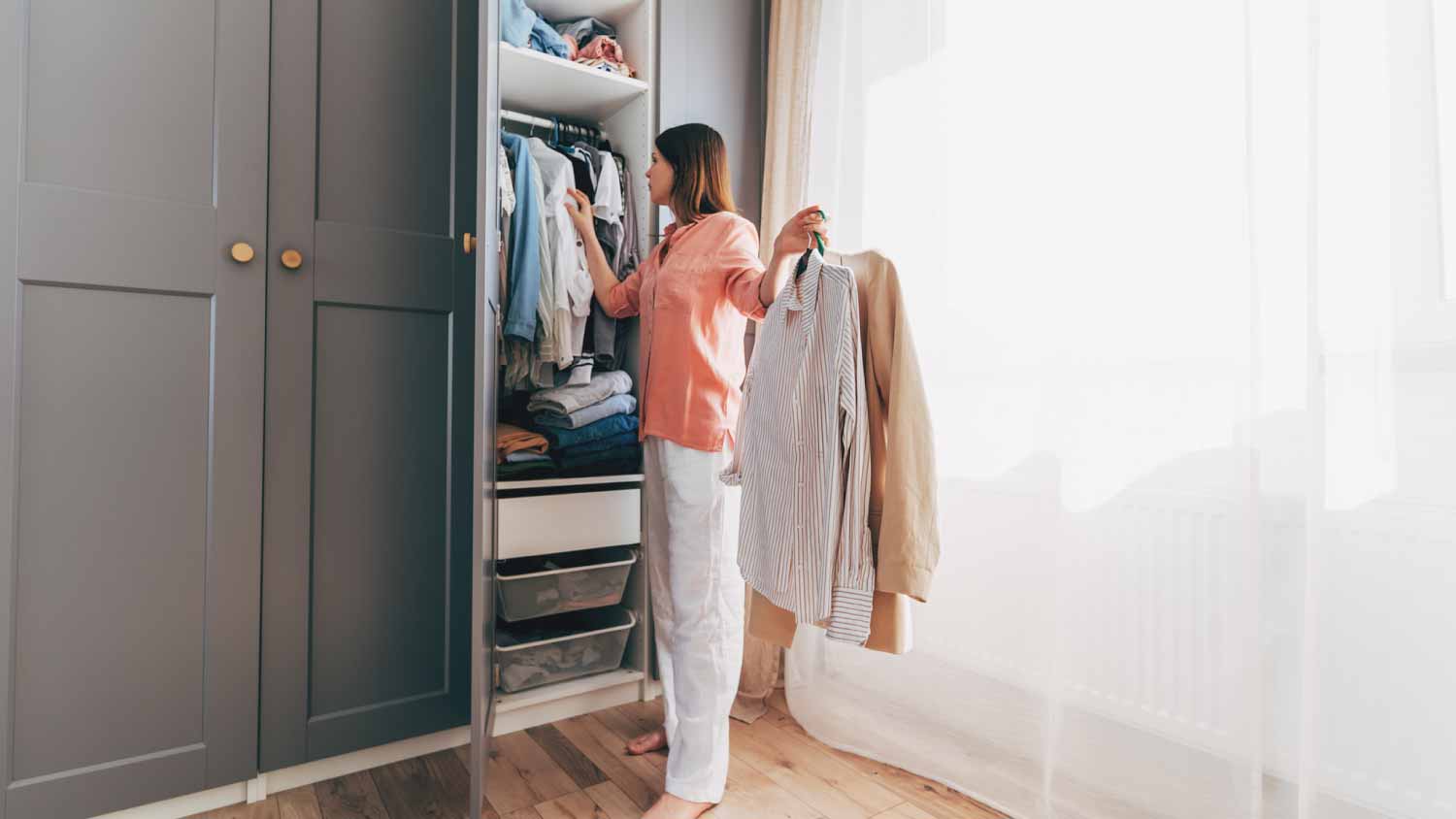 woman standing in front of hanger rack
