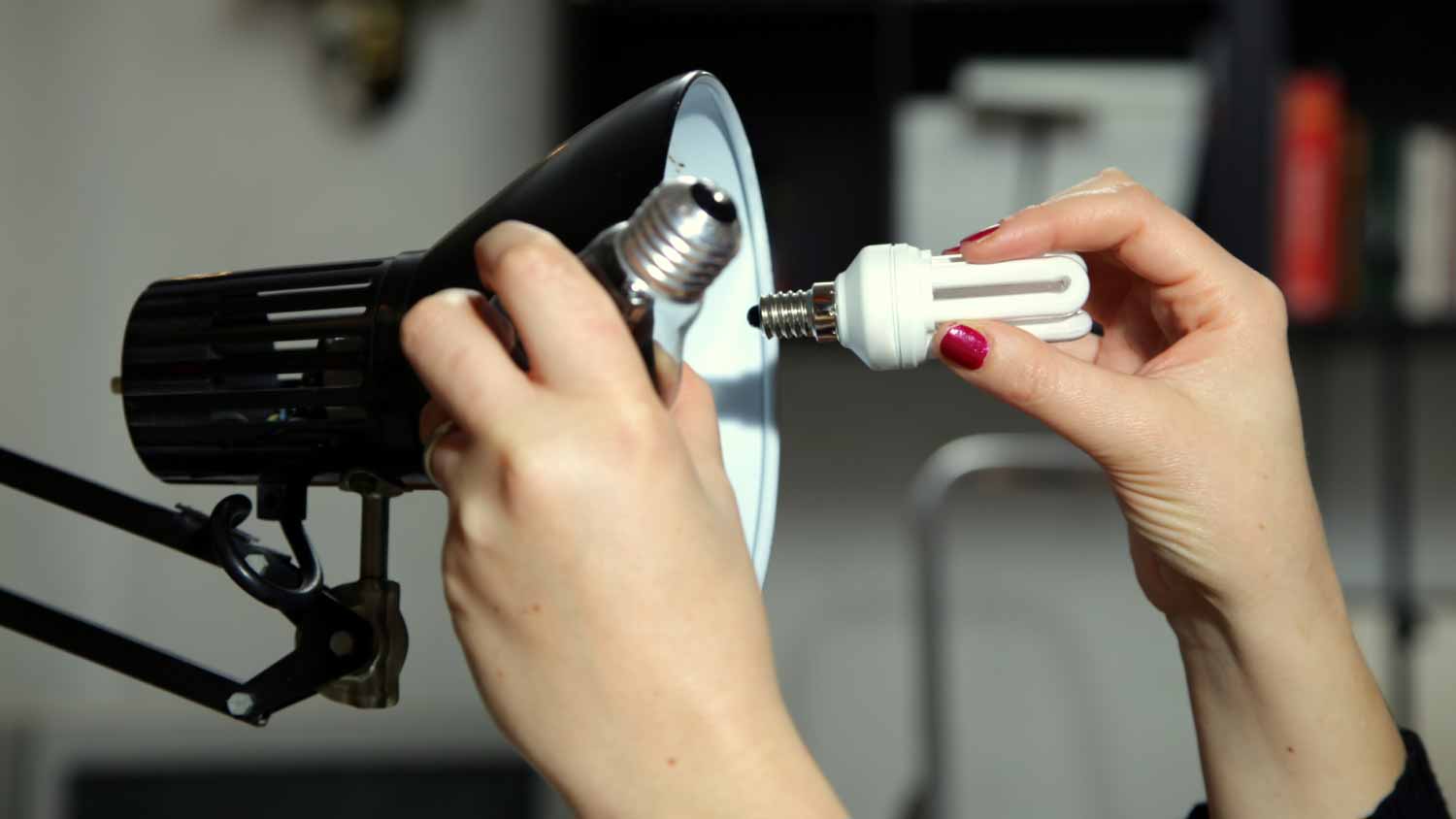 Woman switching light bulb