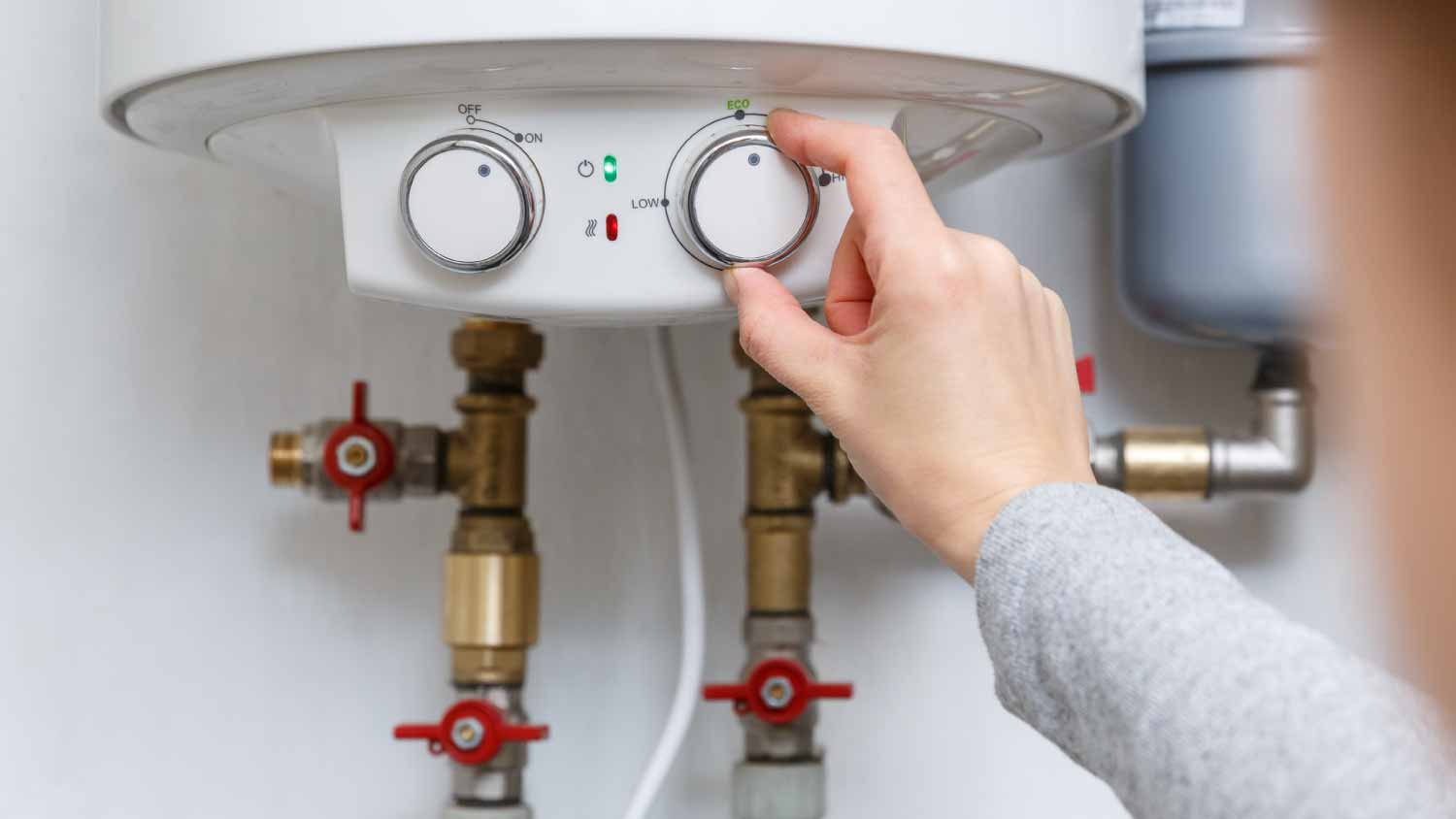 Woman changing thermostat of electric water heater