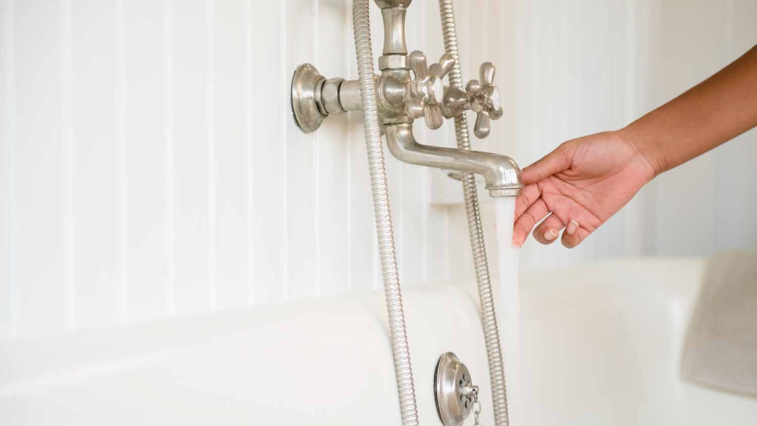 Woman touching water from faucet