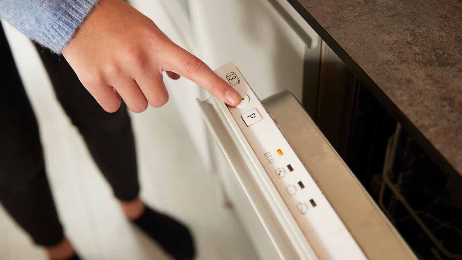A person pressing a button on a diswasher