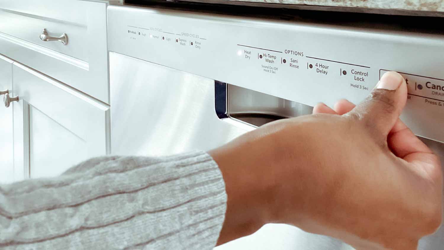 Woman turning on dishwasher