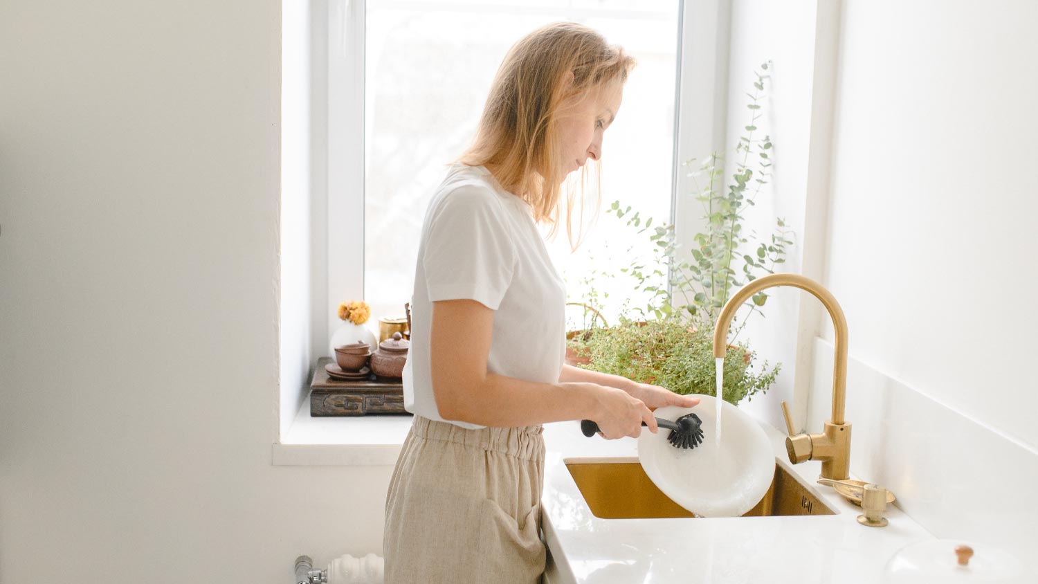 Woman washing dishes in the kitchen