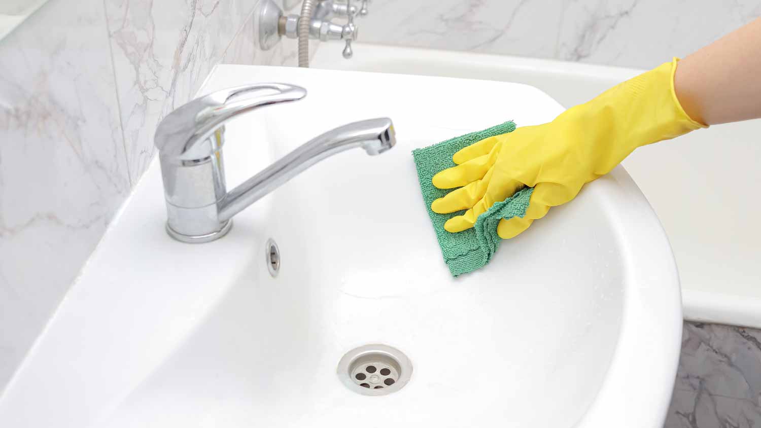 Woman washing the sink in the bathroom