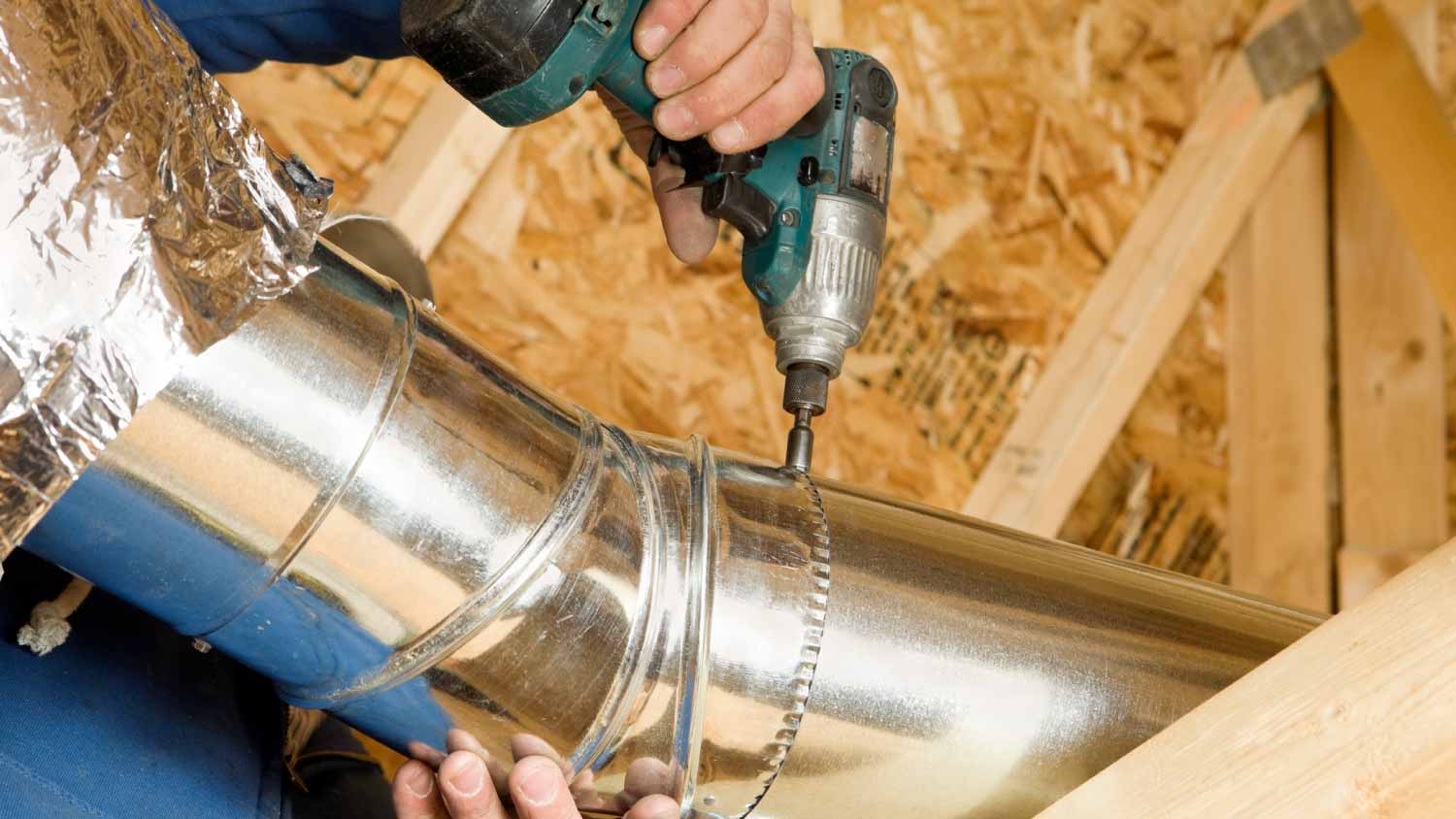 Worker Installing an Attic Vent Duct