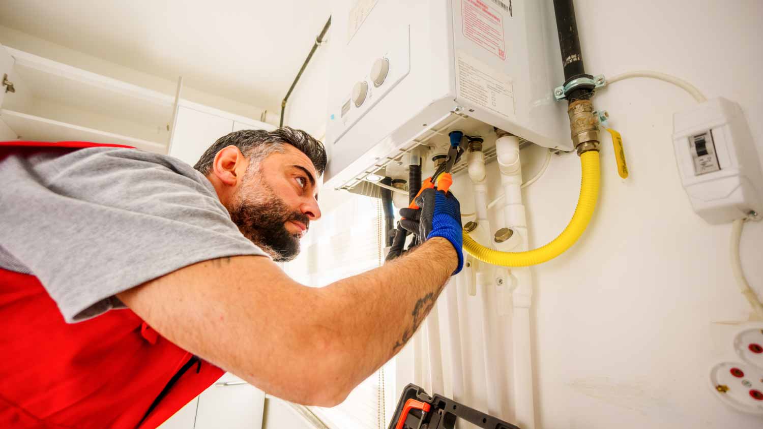 Worker checking gas boiler  