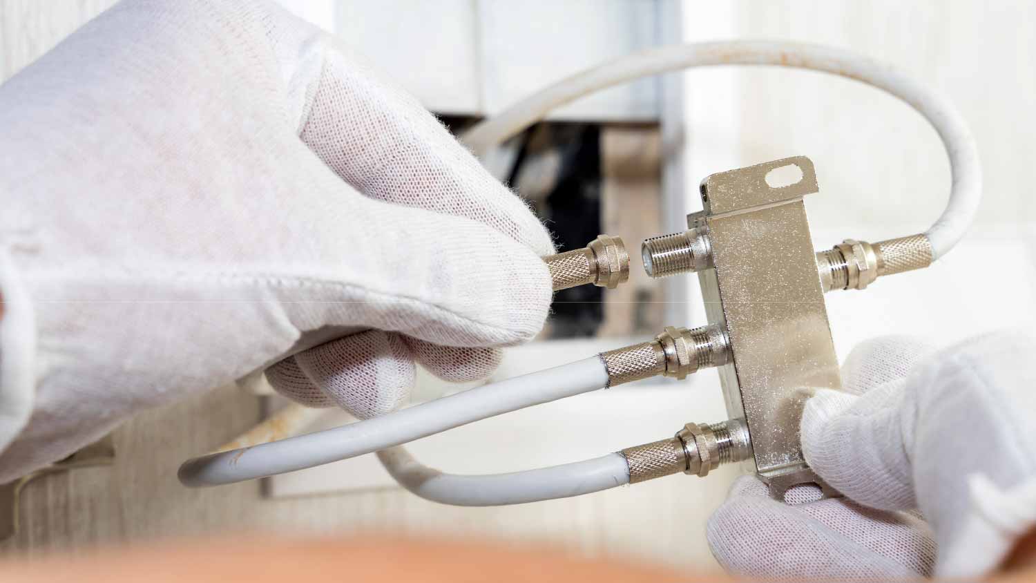 Worker installing antenna coaxial cable to a splitter