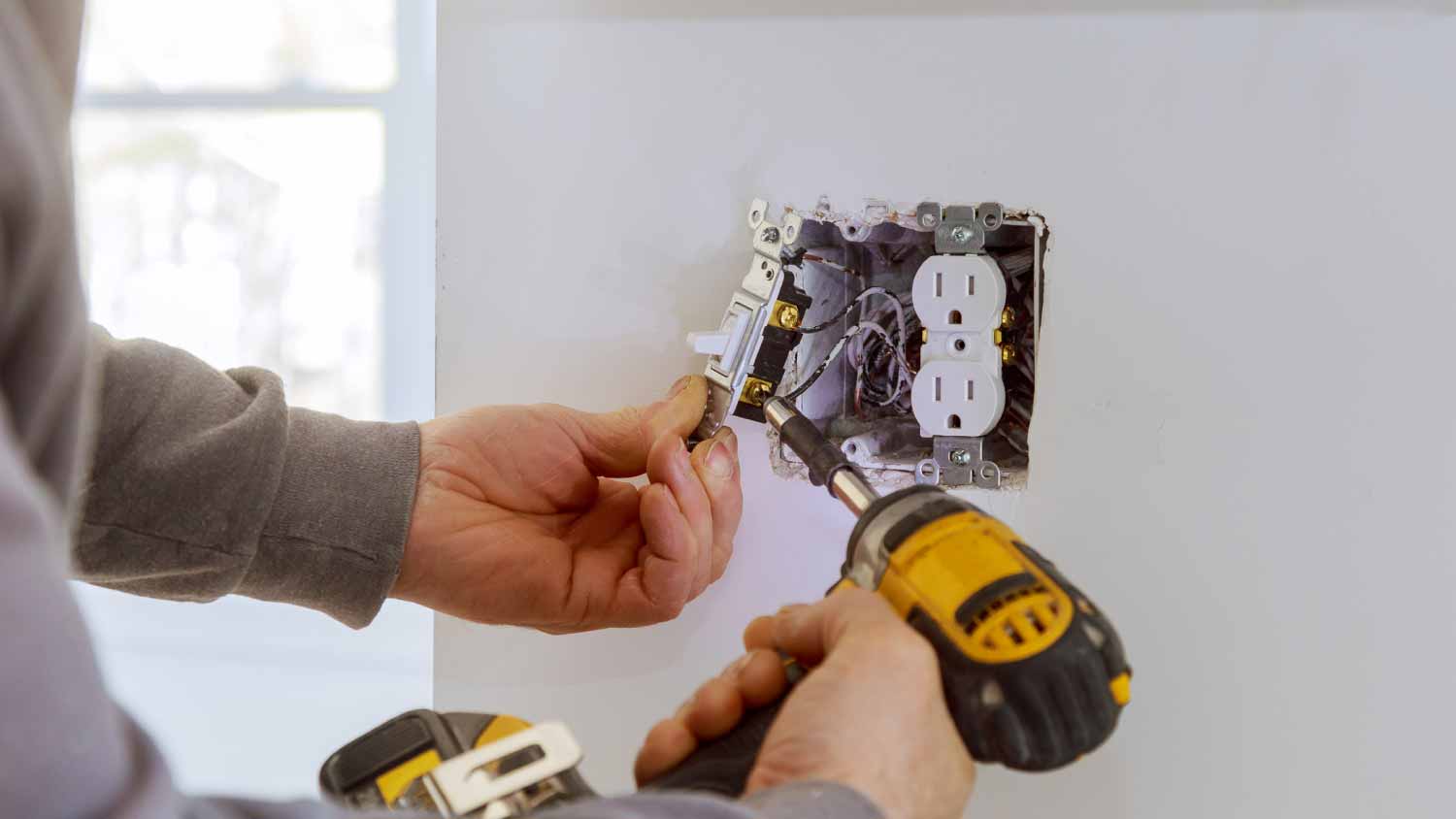 Worker installing electrical outlets