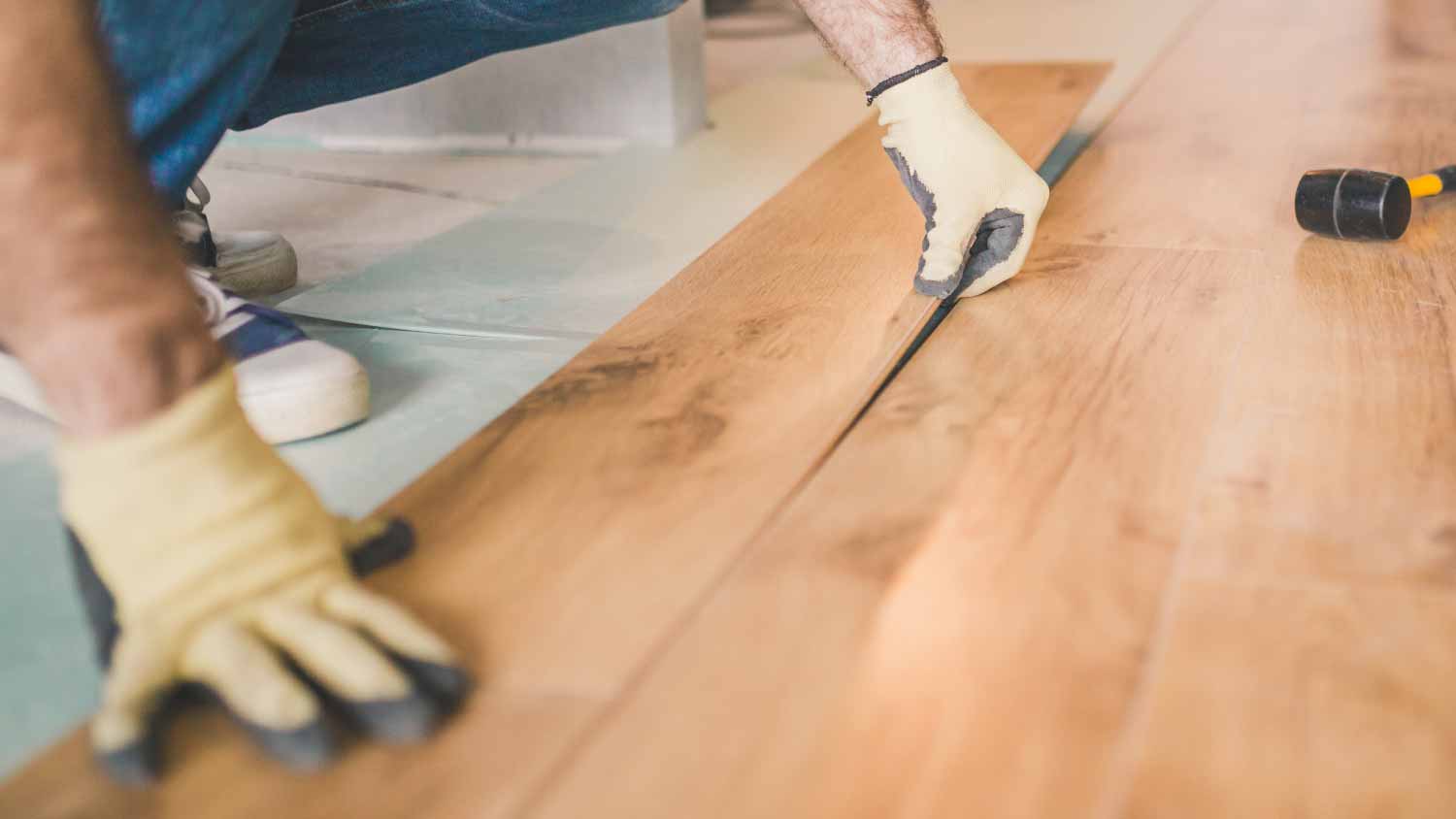 Worker installing laminate floor 
