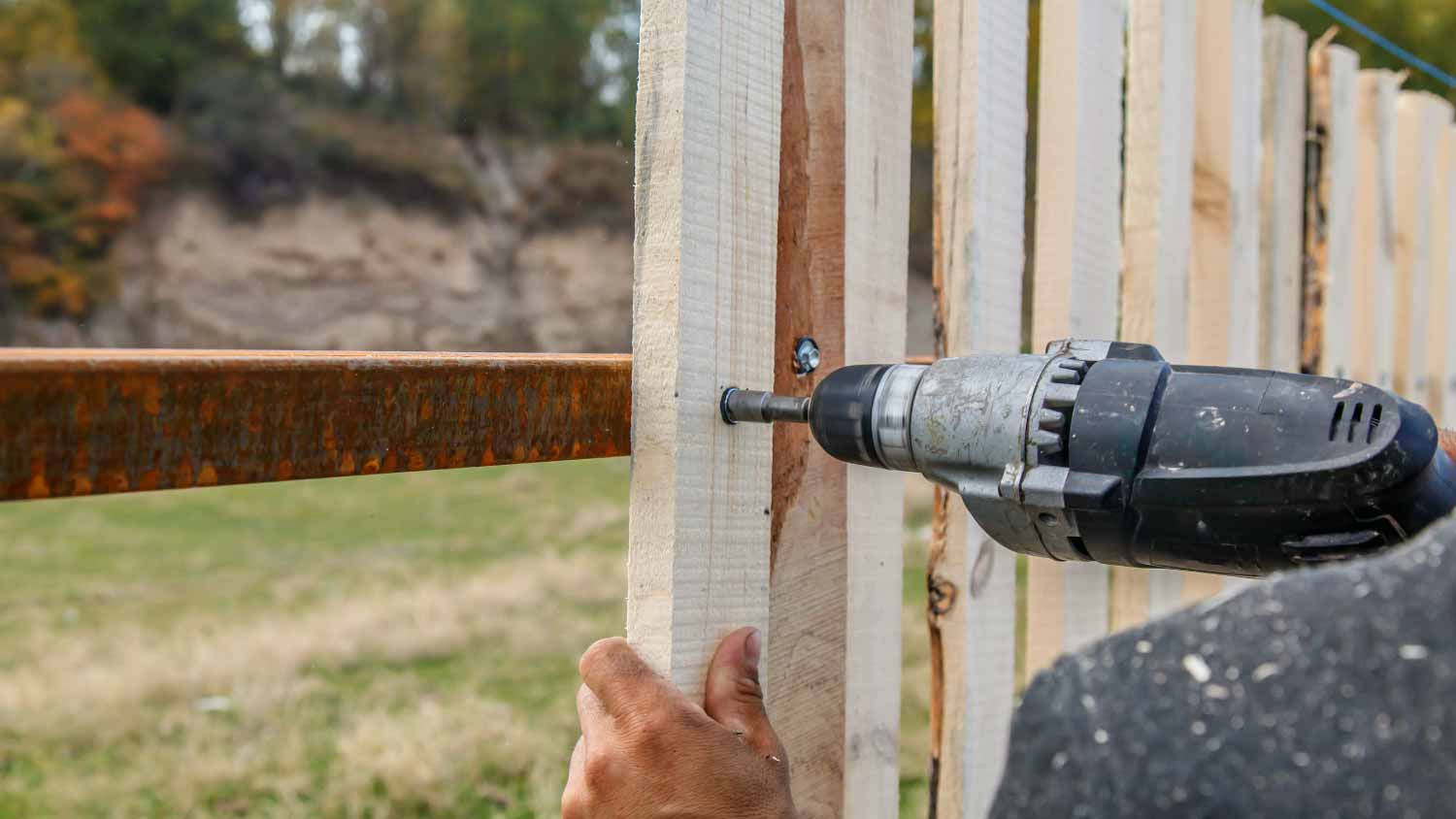 Worker installing picket fence