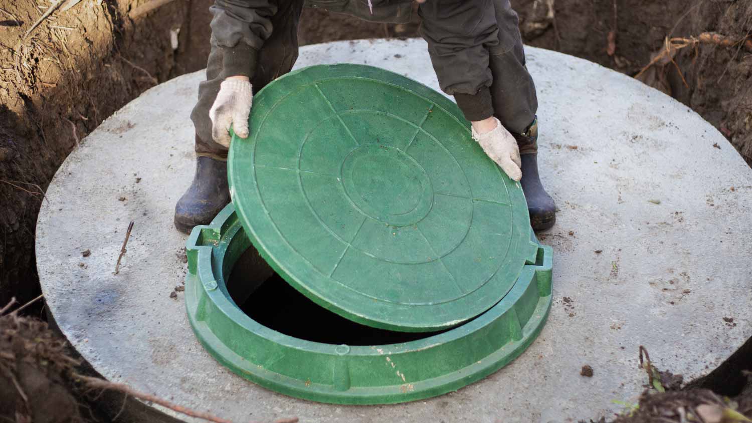 Worker installing a sewer manhole