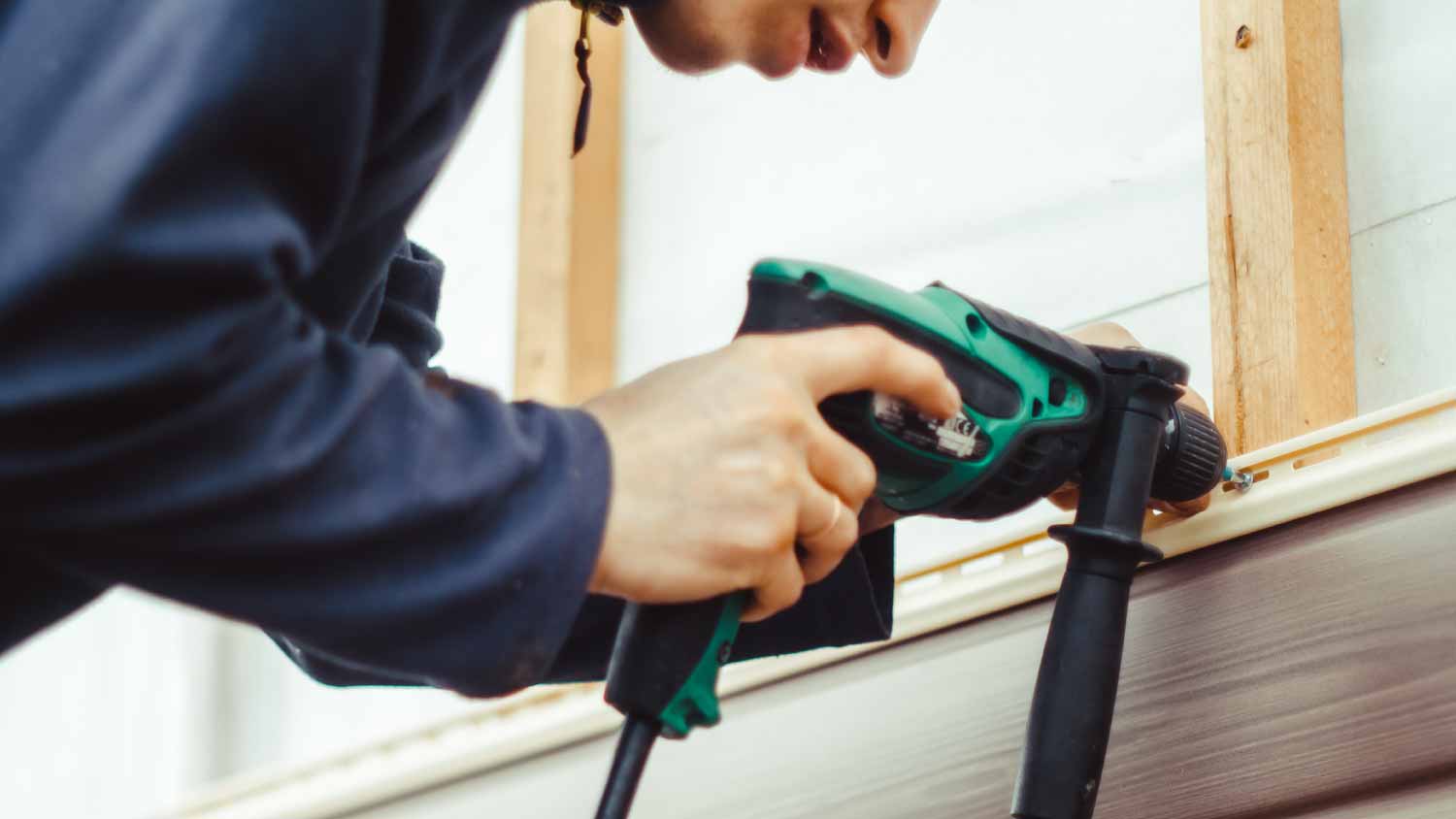 Worker installing vinyl siding