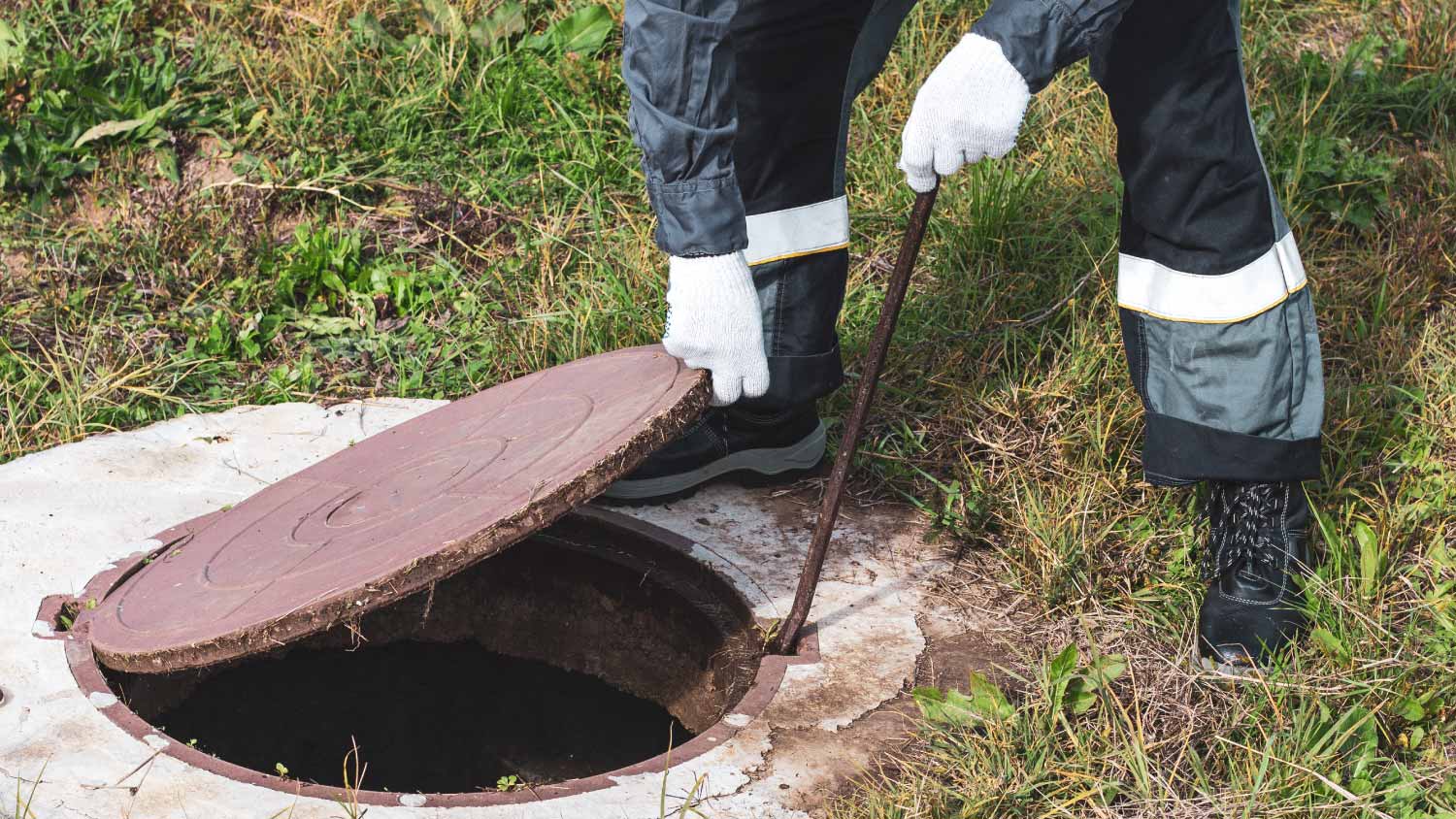 Worker opening the manhole cover