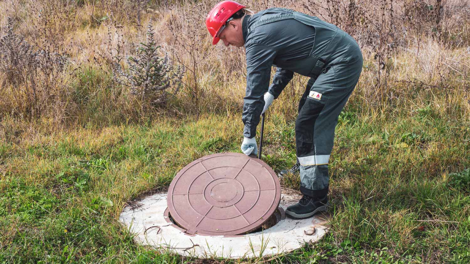 Worker opening a septic tank