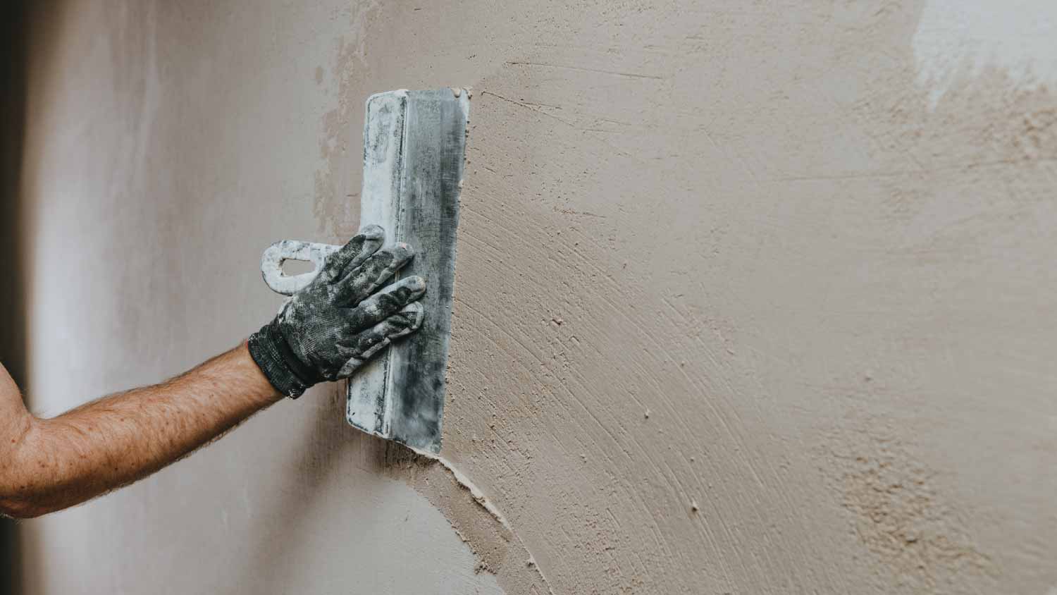 Worker plastering a wall