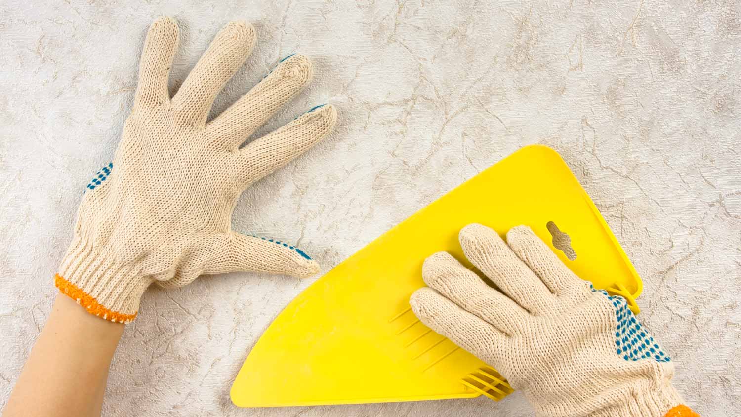 Worker smoothing wallpaper with spatula