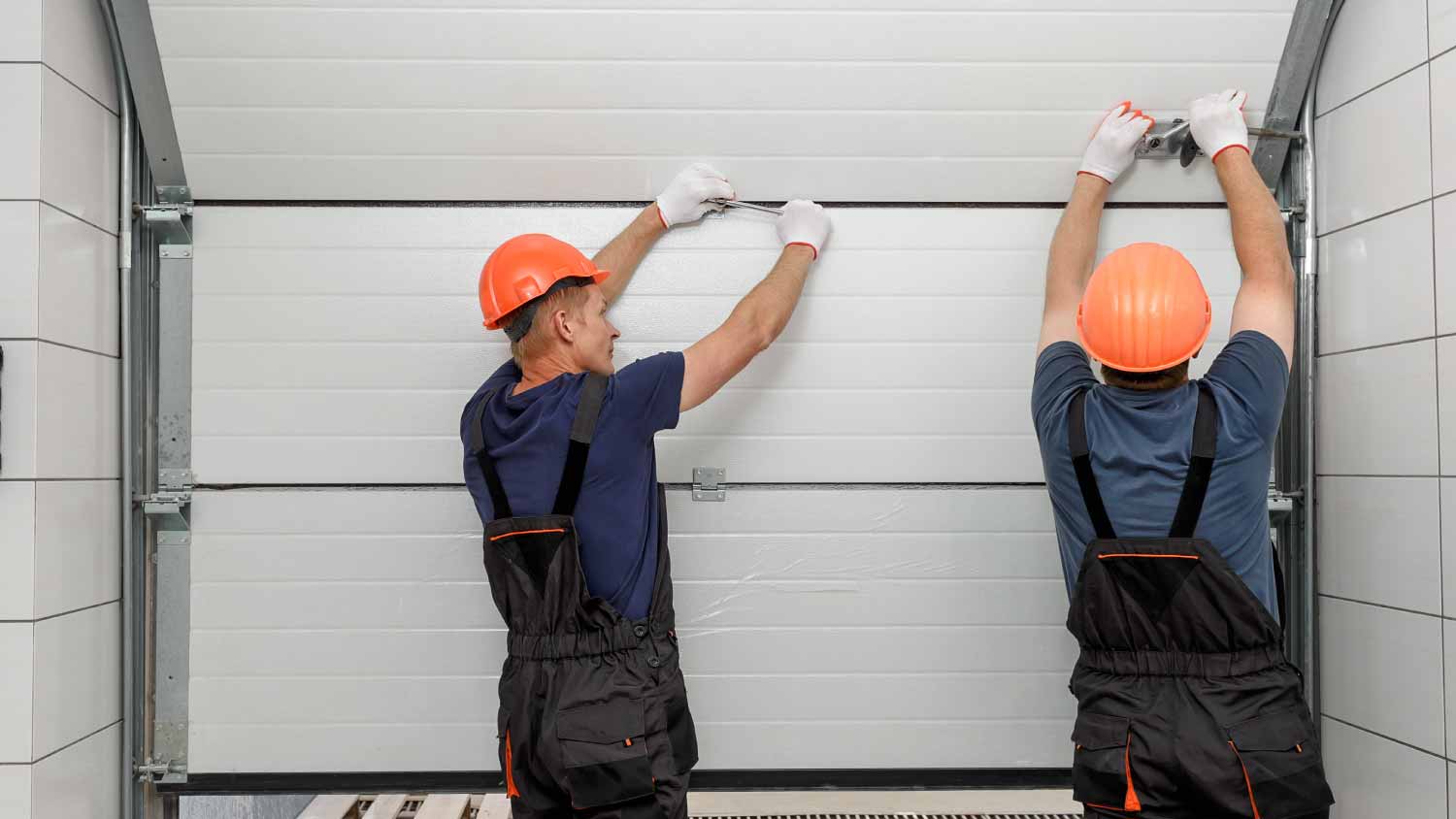 Workers installing garage door