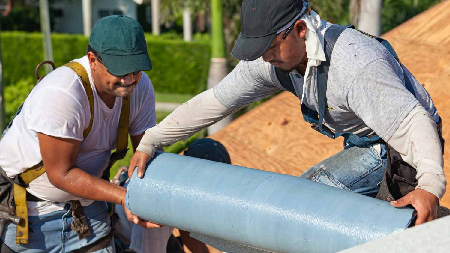 Workers installing roof insulation