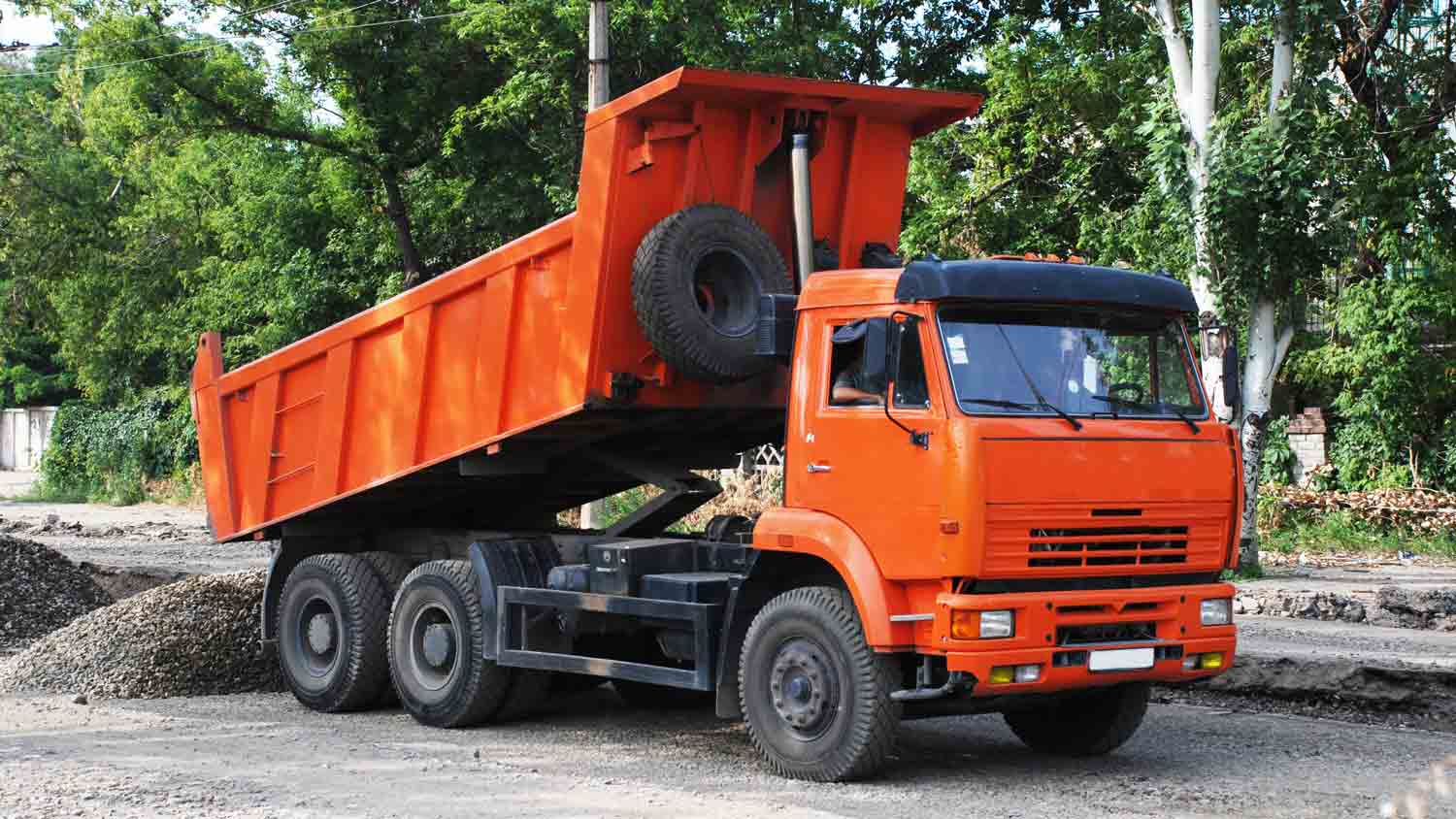 Dump truck unlading gravel on the street