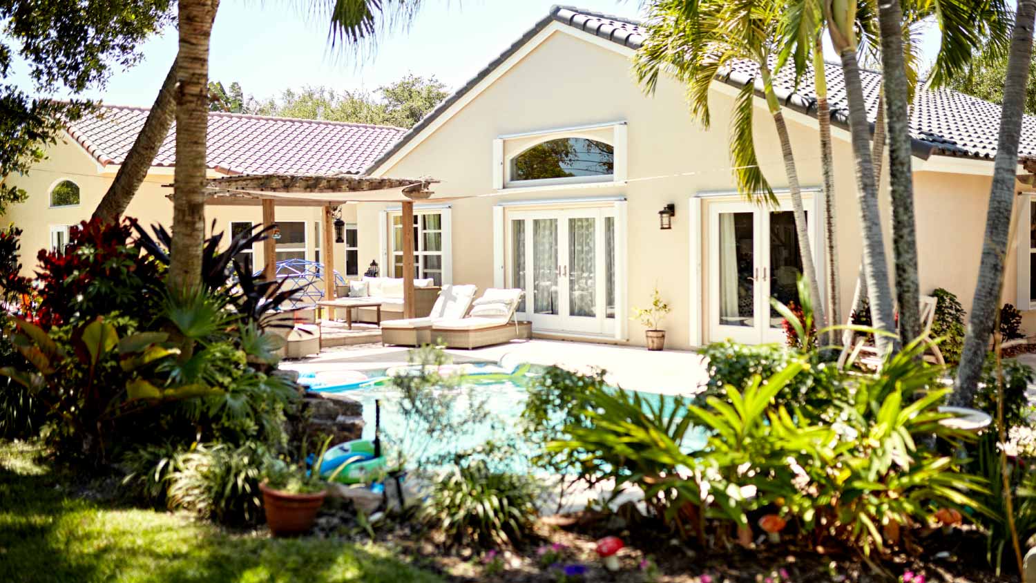 Large backyard with a swimming pool and pergola