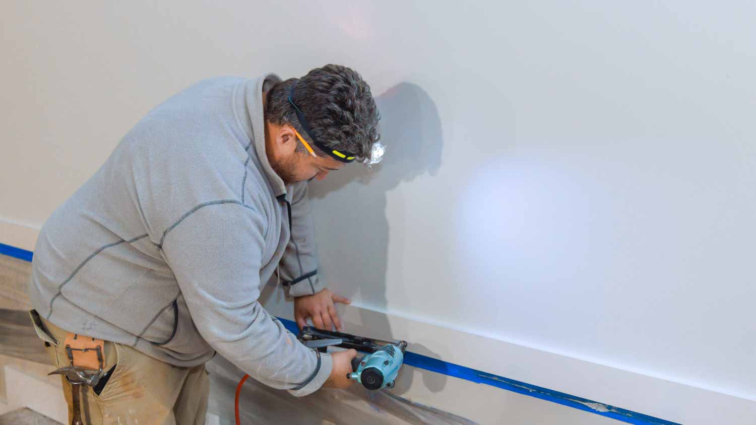 Man installing wooden trim