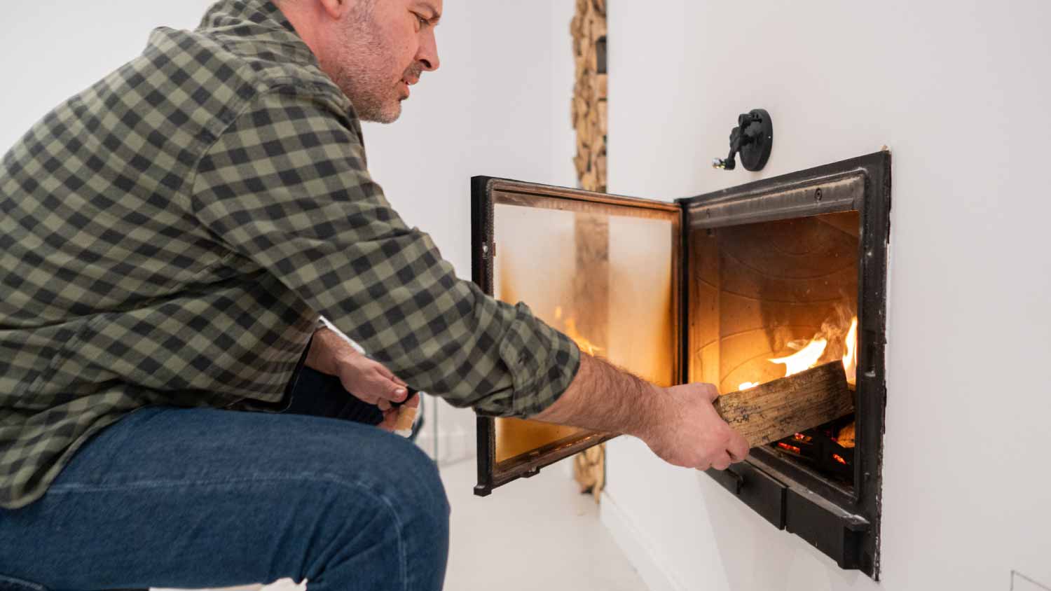 Man putting an log into fireplace