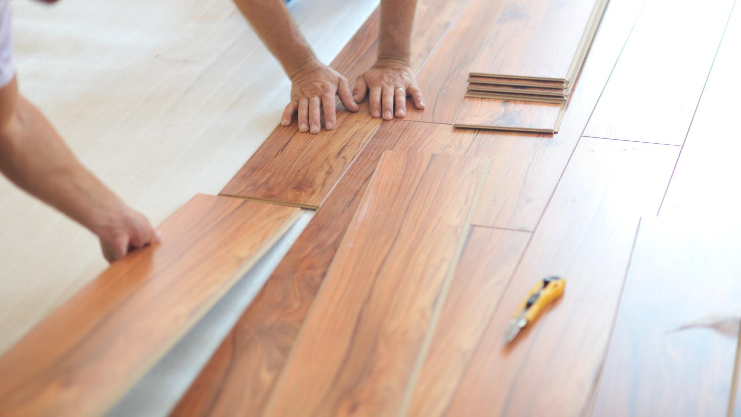 Men installing laminate flooring