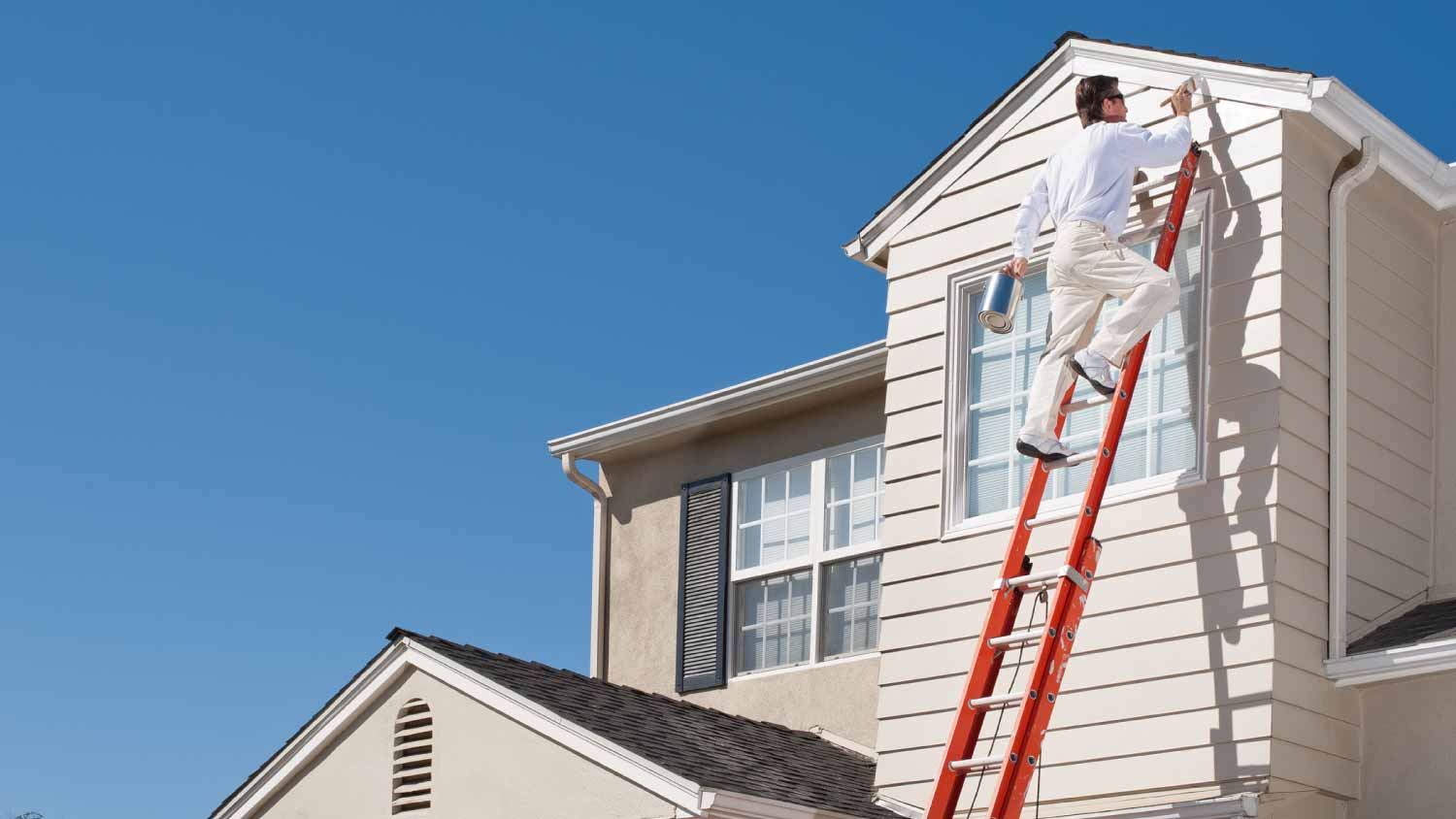 Painter painting the trim of a window