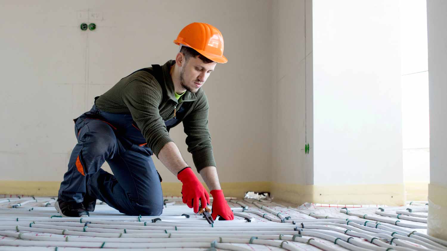 Worker is installing underfloor heating