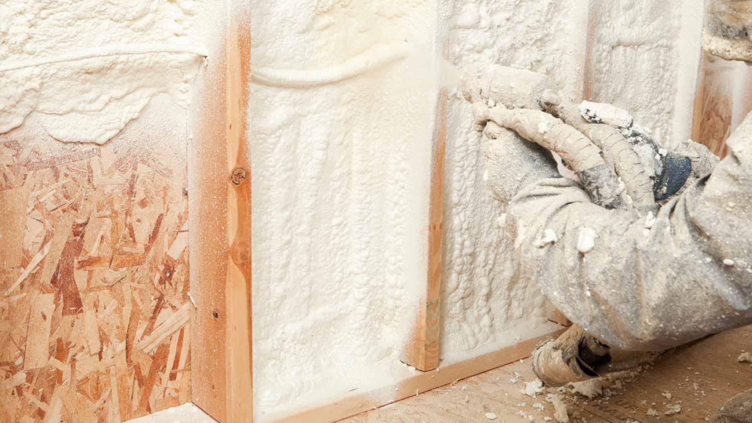 Worker spraying foam insulation