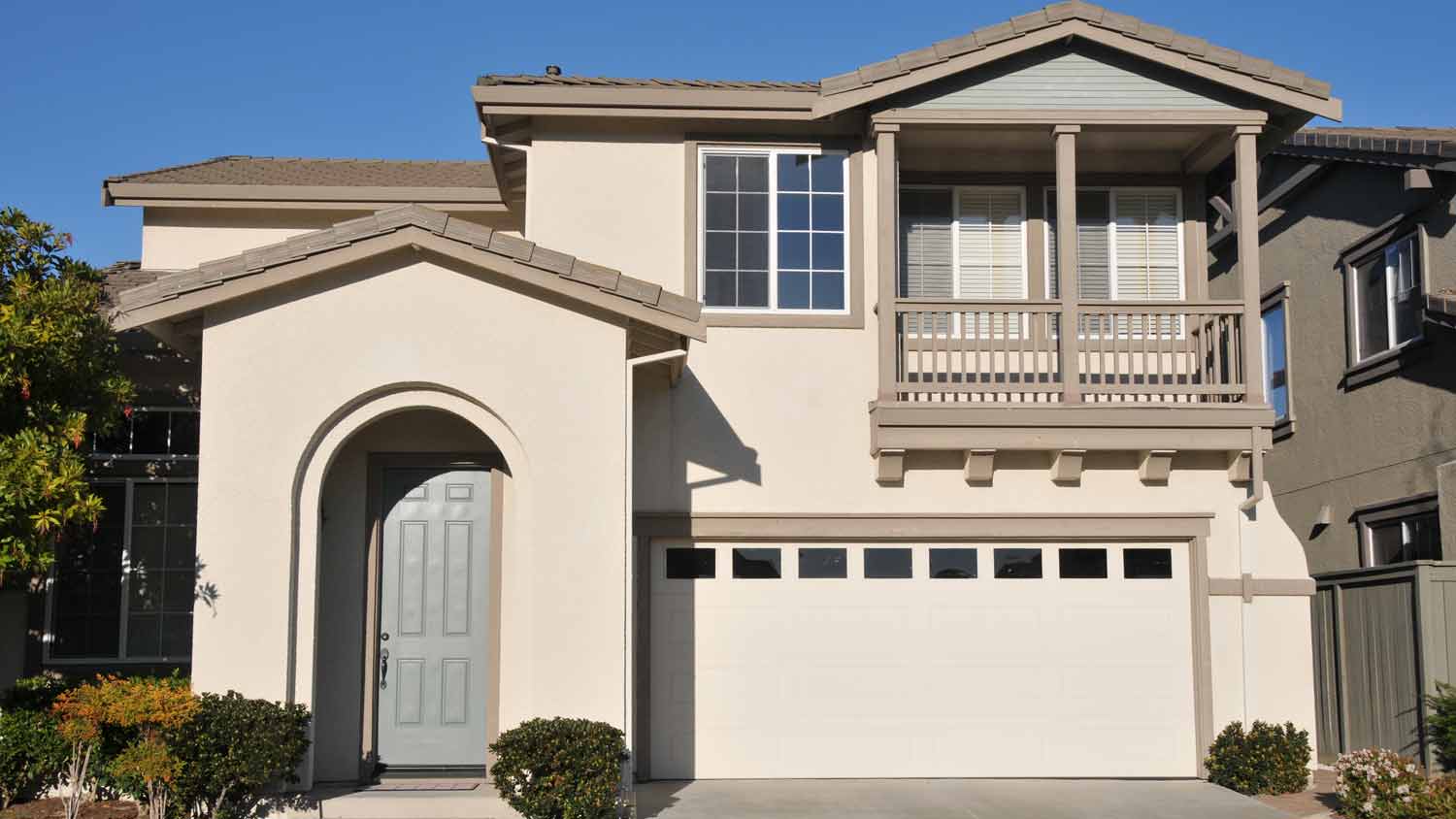 beige two story home with gray door 