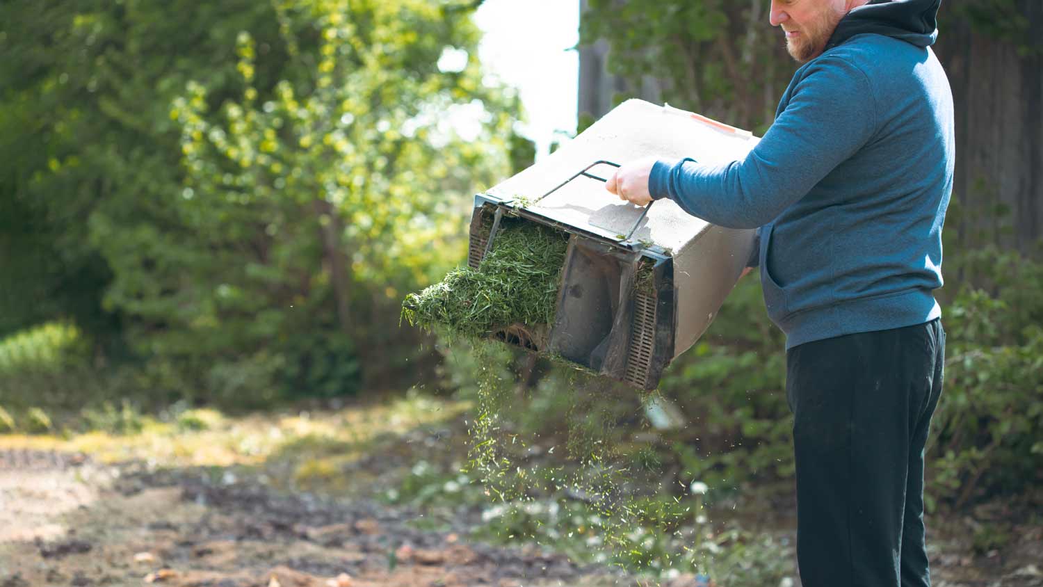 man composting with grass clippings