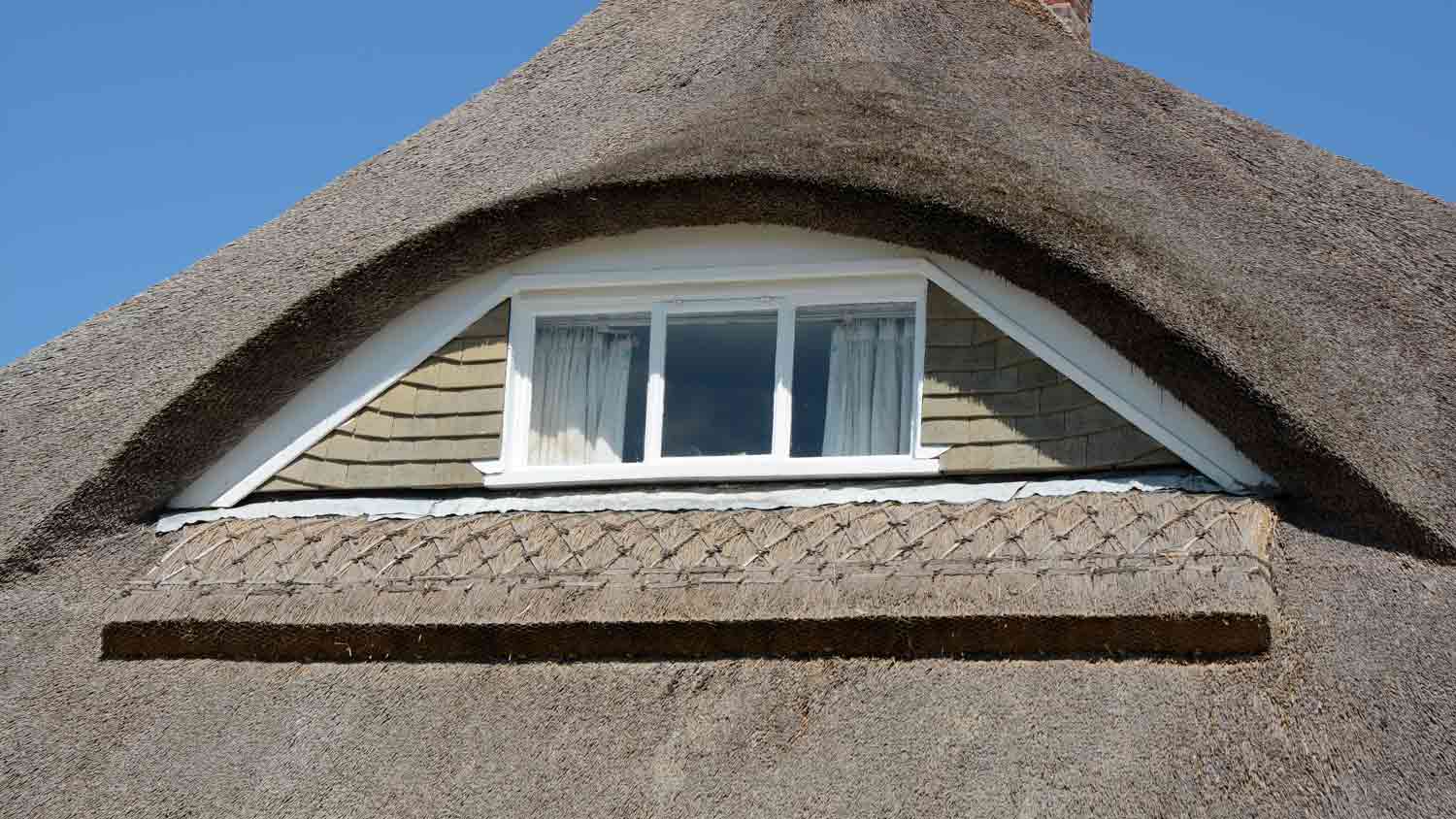 close up of eyebrow window in thatched roof