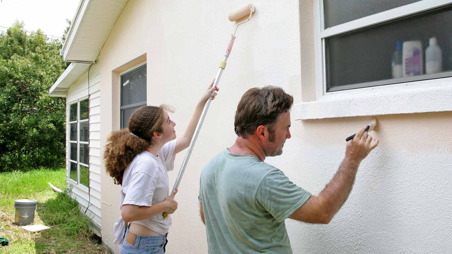 father and daughter paint house exterior