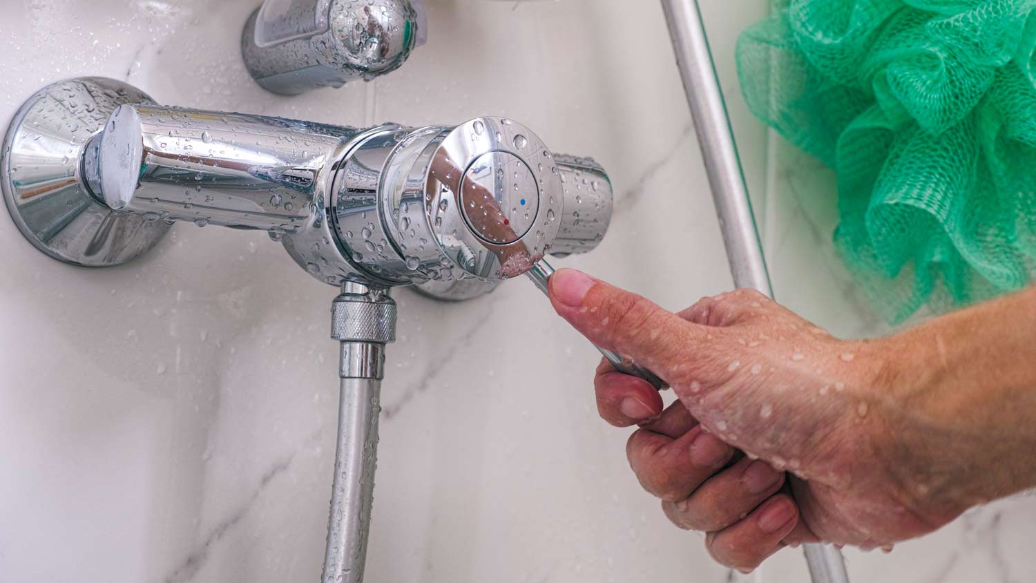 Man’s hand on shower faucet