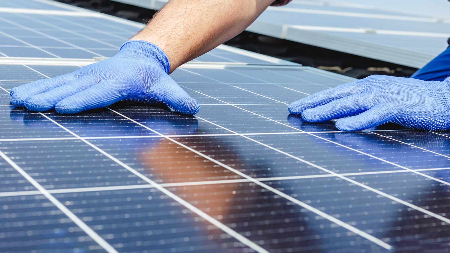 workers hands on solar panels